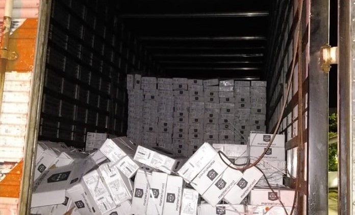 baú do caminhão aberto com centenas de caixas iguais empilhadas os caídas