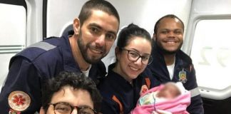 quatro profissinais do samu sorriem para selfie; a médica segura a neném no colo, que está com rosto borrado