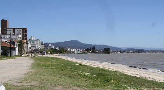 orla de barreiros, com pequena praia, mar sem onda e construção ao longo da orla
