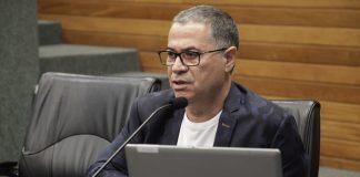 romualdo fala ao microfone com um notebook à frente