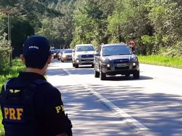 Sem poder autuar por excesso de velocidade, PRF dá 3,4 mil multas em SC policial no ascostamento de rodovia no meio da mata observa carros passando