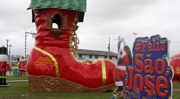 decoração em gramado com uma bota de papai noel gigante e um painel inscrito #felizsãojosé