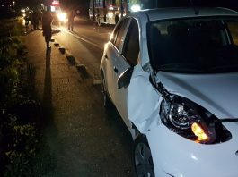 Após um ano e dois dias sem mortes, atropelamento mata mulher na SC 401 nissa march branco com parte da frente batida parado no acostamento e policias e corpo no chão ao fundo em foto noturna