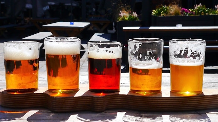 quatro copos de cerveja com diferentes volumes e cores