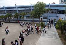 foto do prédio e do pátio do instituto estadual de educação com alunos em uma fila