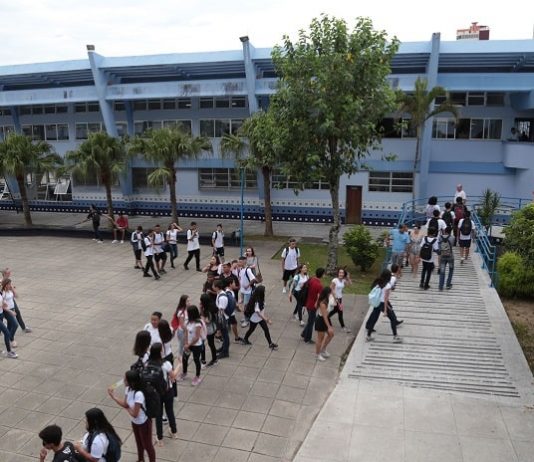 foto do prédio e do pátio do instituto estadual de educação com alunos em uma fila