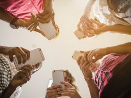 cinco pessoas em roda usando celulares vistas de baixo