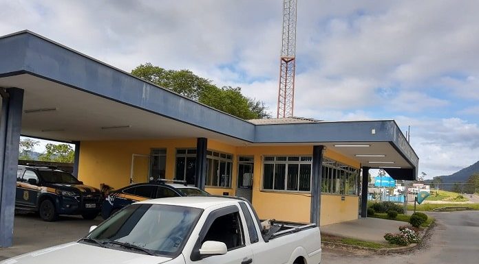 saveiro branca estacionada em frente ao posto da prf, onde há viaturas na garagem