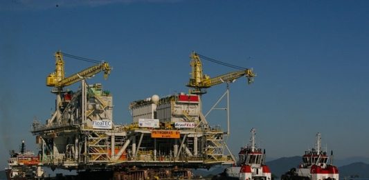 plataforma de petróleo da petrobras com dois navios rebocadores am lado