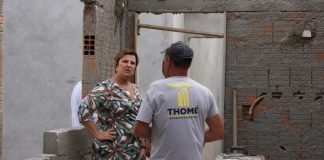 adeliana fala com operários no meio da costrução com pouco reboco nas paredes