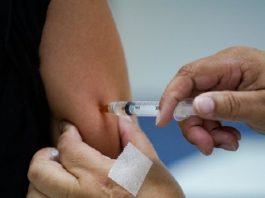 pessoa aplica vacina no braço de outra pessoa