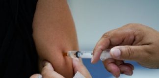 pessoa aplica vacina no braço de outra pessoa