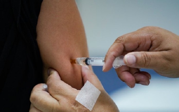pessoa aplica vacina no braço de outra pessoa