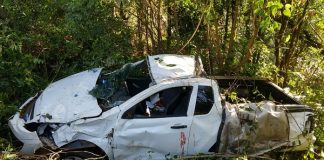 veículo chevrolet montana branco destruído no meio de uma vegetação