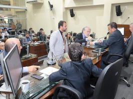 Câmara de Florianópolis aprova orçamento de R$ 2,35 bilhões para 2020 vereadores conversam em volta da mesa diretora da câmara, alguns em pé na frente e outros sentados; plenário ao fundo