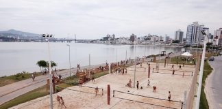 foto aérea das quadras de areia entre o mar e avenida, com pessoas usando e passendo em volta