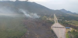 foto aérea da área queimada ao lado da rodovia com pedágio