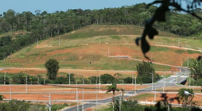 loteamento com ruas e postes, sem nenhuma casa nos lotes e algumas árvores em volta