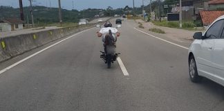 foto de dentro da viatura atrás da moto em que o condutor faz a manobra super-homem