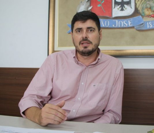 michel fala sentado à mesa de seu gabinete com um quadro com símbolo do legislativo de sj atrás
