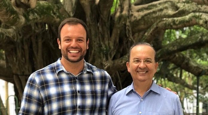 pedrão e jorginho mello sorriem lado a lado para a foto com a figueira da praça xv ao fundo