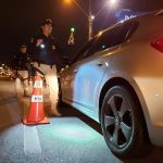 policial feminina com bafômetro passivo ao lado de chevrolet cruze em blitz