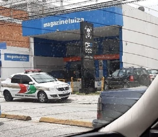 viatura da pm parada em frente à loja magazine luiza; foto tirada de dentro de carro