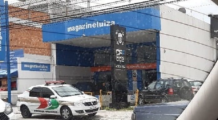 viatura da pm parada em frente à loja magazine luiza; foto tirada de dentro de carro