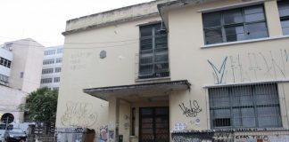 fachada do prédio depredada e pixada, que fica em uma esquina