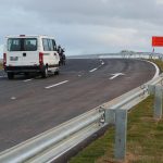 van passando em curva de viaduto em trecho do novo acesso com placa "conversão à direita"