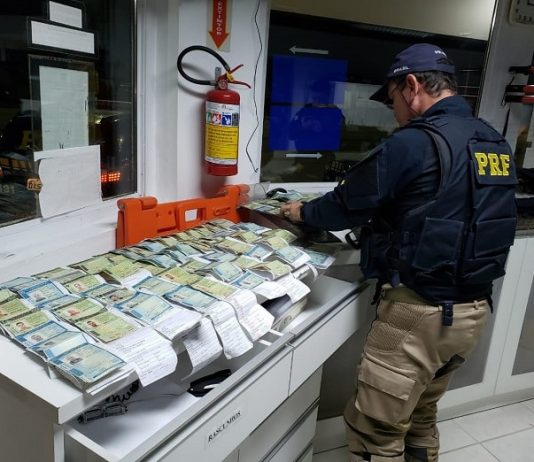Santa Catarina tem o maior número de flagrantes de embriaguez nas rodovias federais do Brasil agente da prf confere dezenas de cnh dispostas alinhadas sobre um balcão