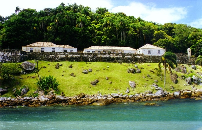 edificações em uma ilha com gramado que chega até à beira do mar