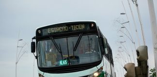 ônibus da empresa Jotur descendo a ponte visto de frente com a linha estação - ticen inscrita na parte frontal