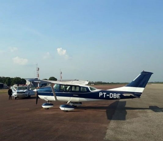 aeronave de prefixo pt-dbe estacionada em aeroporto com viatura ao lado