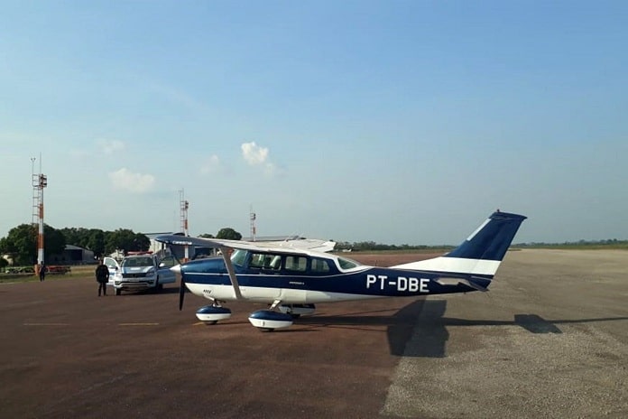 aeronave de prefixo pt-dbe estacionada em aeroporto com viatura ao lado