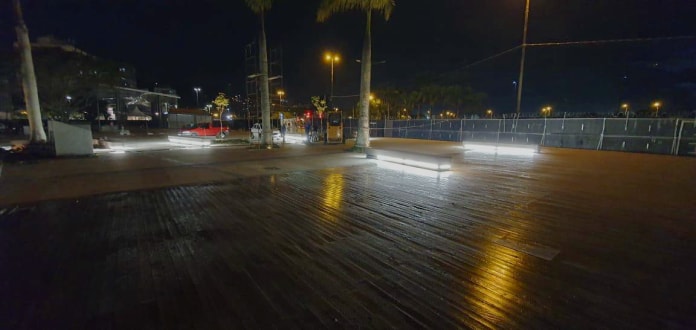 área dos decks de madeira iluminada por luzes em baixo dos bancos
