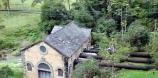 usina vista de cima, com canos indo à casa de força e riacho ao lado