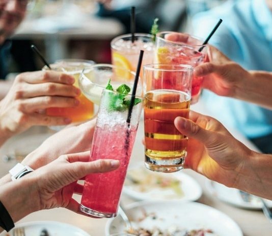 close em grupo brindando com diferentes tipos de bebidas e drinks