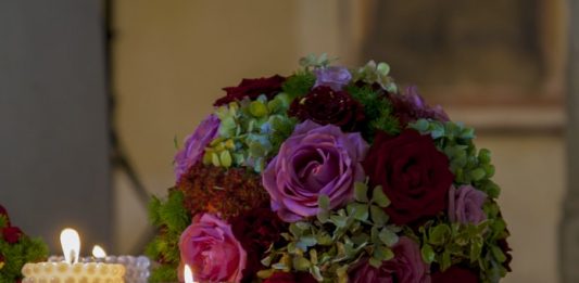 Noivos que tiveram festa de casamento às escuras serão indenizados pela Celesc duas velas acesas ao lado de um buquê de casamento