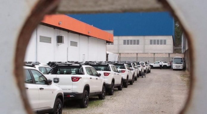 fiat toro estacionadas juntas em pátio vistas por um buraco no portão