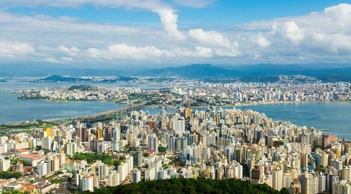 iptu 2021 Florianópolis: foto do alto do morro da cruz mostrando centro de florianópolis, continente e região metropolitana com céu com nuvens ao fundo