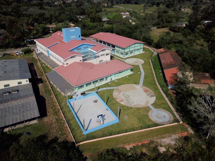 foto aérea de prédio e pátio da escola no ratones, com campos e vegetação em volta