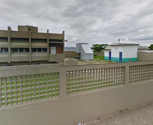 estação de esgoto vista da rua, atrás do muro