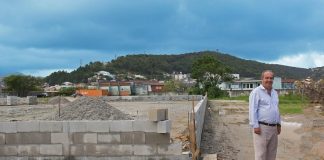 neri posa para foto ao lado de muro em construção