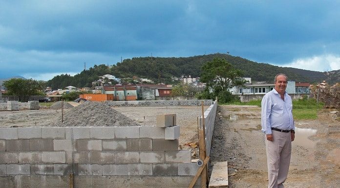 neri posa para foto ao lado de muro em construção