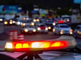 Estudo aponta que SC é 2º colocado em resolução de crimes giroflex de uma viatura ligado em destaque com carros passando em avenida ao fundo