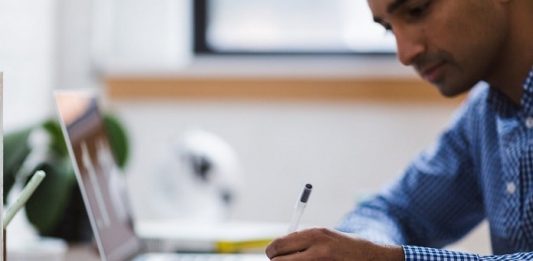 Programa de bolsas universitárias estaduais terá R$ 206 milhões para 2020 homem fazendo anotaçoes em um caderno ao lado de um notebook