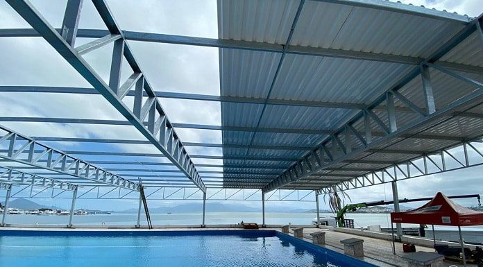 cobertura sendo construída sobre a piscina com mar ao fundo