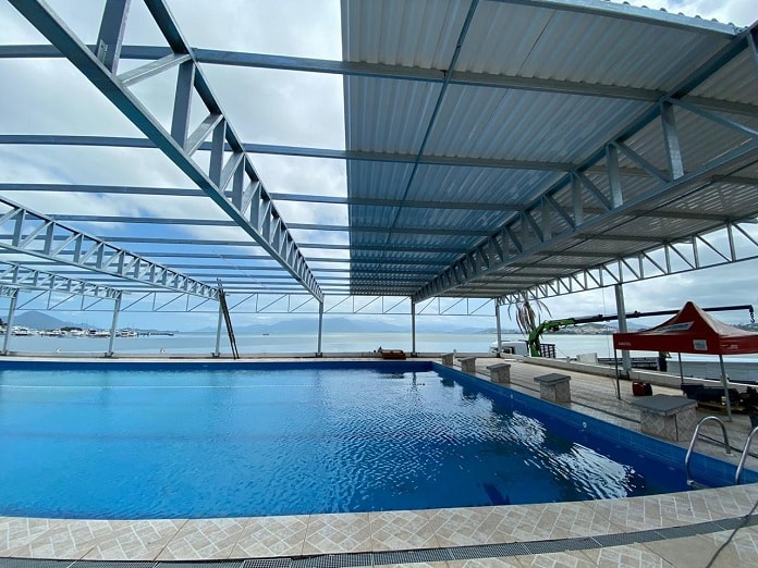 cobertura sendo construída sobre a piscina com mar ao fundo