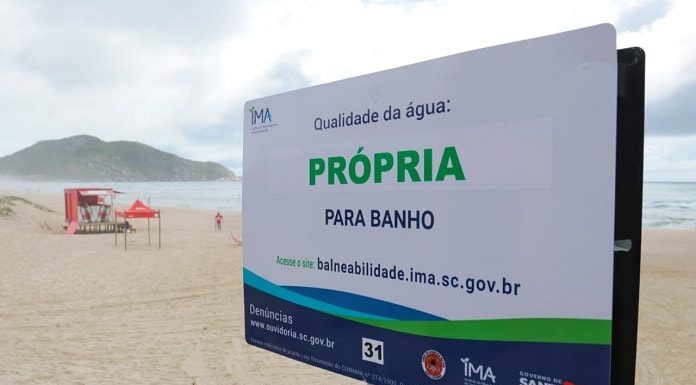 placa do ima em praia com destaque para a frase "própria para banho"